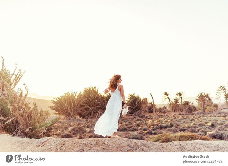 Frau in weißem Kleid auf trockenem Feld im Sonnenlicht stylisch laufen trocknen Licht Landschaft Natur Sommer Schönheit Tag schön natürlich genießend romantisch