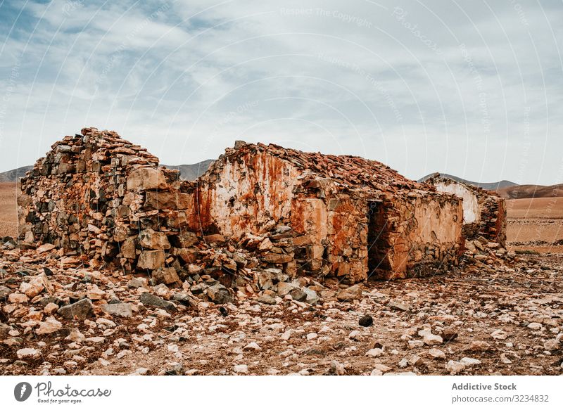 Verwahrloste alte Gebäude in Bergwüste unter bewölktem Himmel Haus verfallen antik Architektur Stein schäbig Struktur Eingang erstaunlich rustikal Außenseite