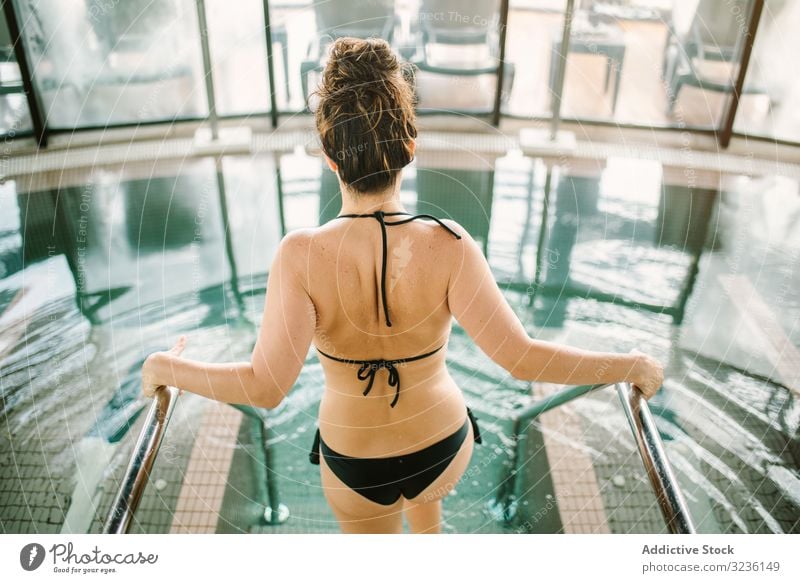 Attraktive Frau geht im Schwimmbad spazieren Pool Spa Wellness Wasser Schwimmsport Erholung Zentrum Bikini hereinspazieren attraktiv brünett passen jung