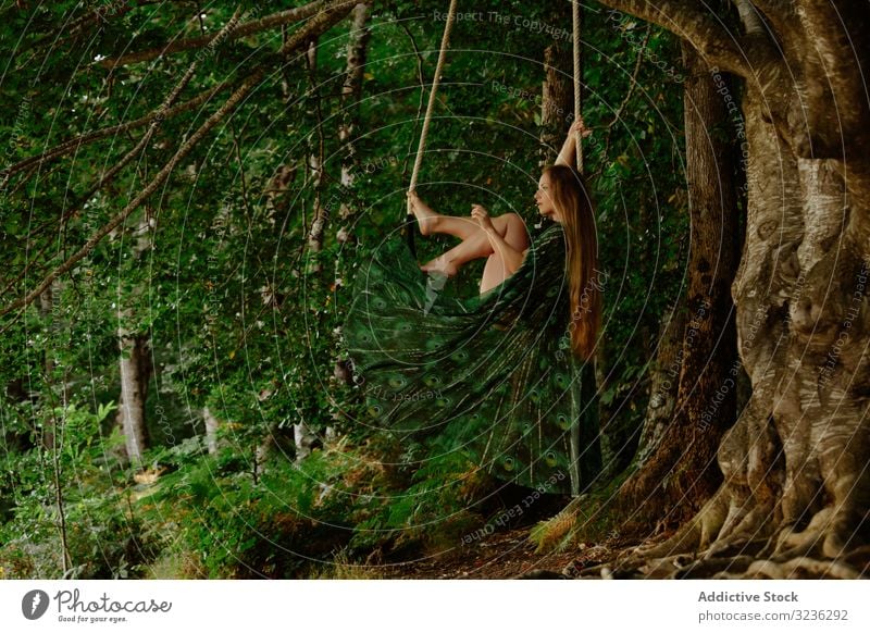 Liebevolle Oben-ohne-Frau schwingt am Trapez im Wald swinging oben ohne Konzept anhänglich unverhüllt traumhaft schlank lange Haare erhängen Schwingbügel ruhig