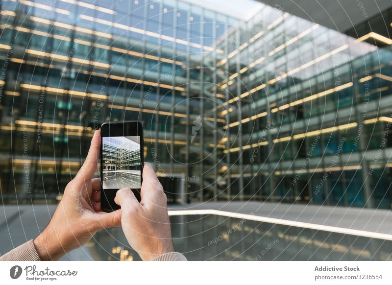 Mann schießt mit Smartphone auf Gebäudefassade in der Innenstadt fotografierend Wolkenkratzer Fassade Business Bildschirm Stadtzentrum Straße urban Fotografie