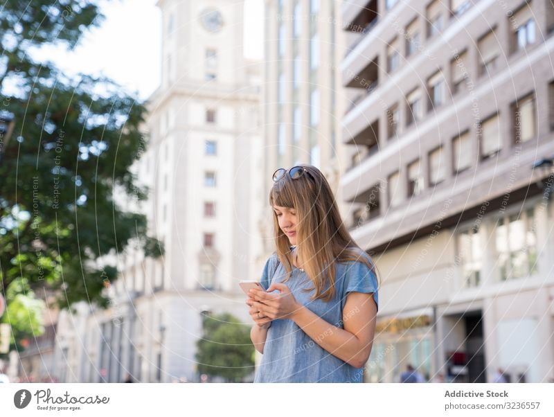 Frau mit Brille mit Smartphone im Freien Großstadt heiter lässig Sonnenbrille Straße Nachricht Lifestyle Tippen benutzend Mobile Apparatur SMS urban Antwort