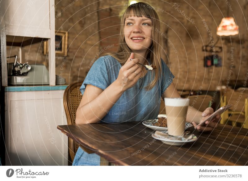 Frau hält Löffel mit Tortenscheibe Kuchen Café Scheibe Spielfigur Kaffee Lifestyle jung Glück geschmackvoll heiter Freizeit trinken lässig versuchen Sie
