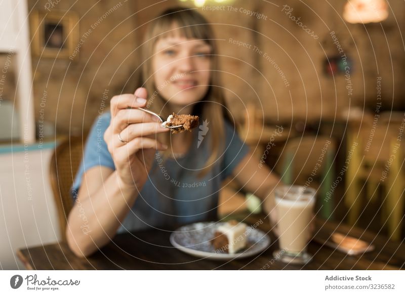 Frau hält Löffel mit Tortenscheibe Kuchen Café Scheibe Geben Spielfigur Kaffee Lifestyle jung Glück Angebot geschmackvoll heiter Freizeit trinken lässig