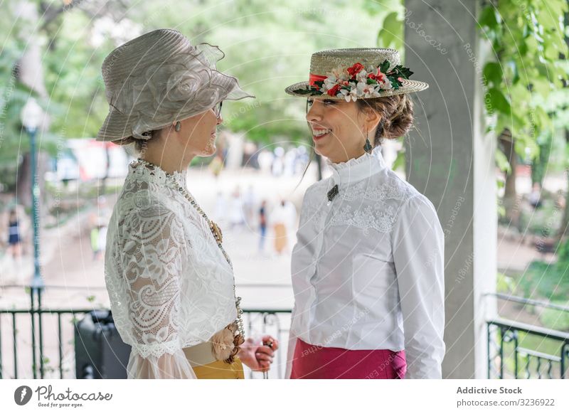 Alte Freundinnen sprechen im Garten Frauen Lächeln altehrwürdig Park Bluse Hut Tracht elegant Sommer altmodisch klassisch Accessoire retro Outfit Dame