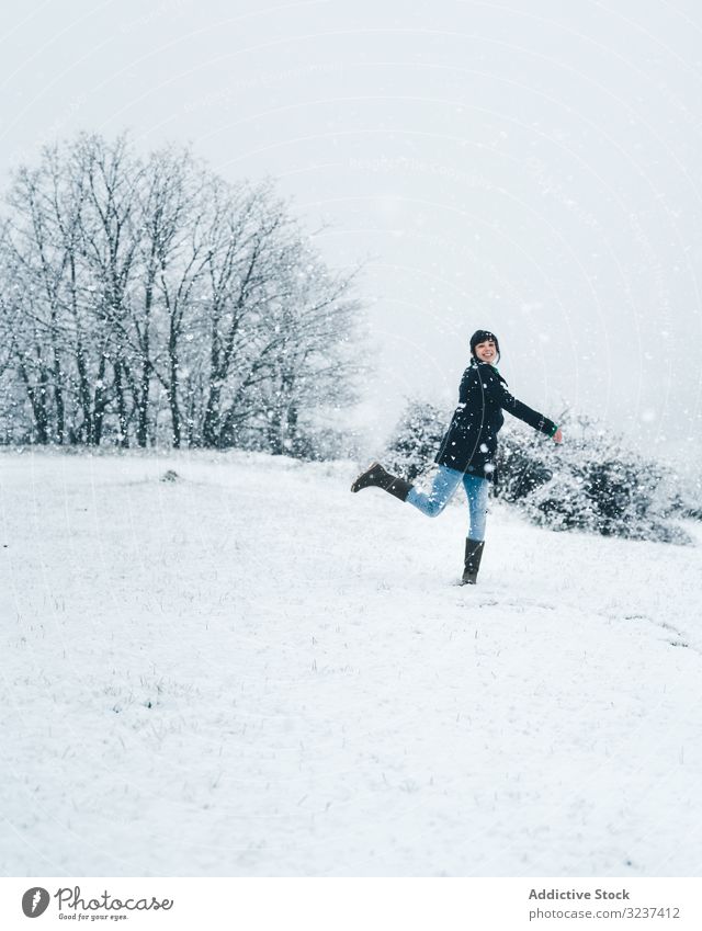 Frau spielt mit Schnee auf Winterfeld Feld Spielen Erholung genießen Land Wald allein Wiese Hügel Baum gefroren ruhig springend Windstille kalt Natur