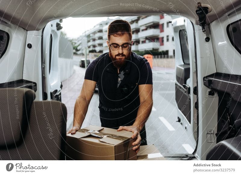 Kurier, der Kartons mit dem Auto zur Fertigstellung der Lieferung herausbringt Mann Versand Kasten PKW hochladen nachdenklich vorsichtig Straße Orden Dienst