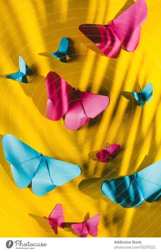 Papierschmetterlinge auf gelbem Karton Schmetterling Dekor behauen handgefertigt heimwärts Form Zusammensetzung Kunst hell lebhaft pulsierend Origami