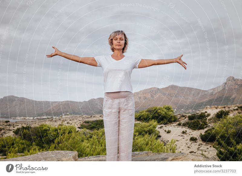 Barfüßige Frau meditiert auf Stein Meditation Übung Felsen Tai Chi geschlossene Augen Natur Himmel wolkig Training Erwachsener Barfuß Atem Gesundheit passen
