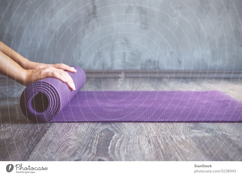 Frau rollt ihre Matte nach einem Yoga-Kurs Lifestyle schön Körper Erholung Meditation Sport Mensch Erwachsene Fitness dünn jung üben Pose Training Gesundheit