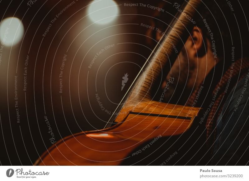 Cello spielender Mann Musik Schauplatz Orchester Konzert Farbfoto Musiker Musik hören Detailaufnahme Innenaufnahme Kunst Kunstlicht Textfreiraum Nahaufnahme