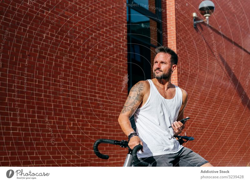 Sportlicher Mann mit Fahrrad beim Telefonieren stehen Handy benutzend modern sportlich aktiv Sommer männlich Radfahrer Smartphone Nachricht Texten Überprüfung