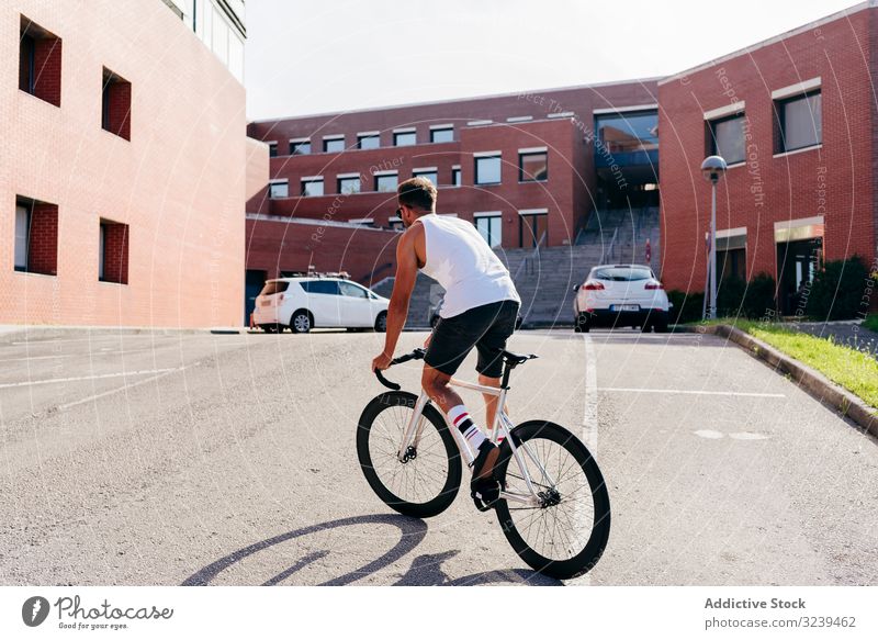 Mann fährt Fahrrad neben Gebäuden Mitfahrgelegenheit Brücke Großstadt modern aktiv sportlich Sommer männlich Sonnenbrille Radfahrer Erholung Gesundheit