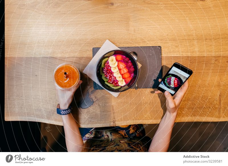 Frau fotografiert eine Obstschale mit einem Smartphone fotografierend Lebensmittel Schalen & Schüsseln Frucht Tisch hölzern Saft Gesundheit Bild Mobile