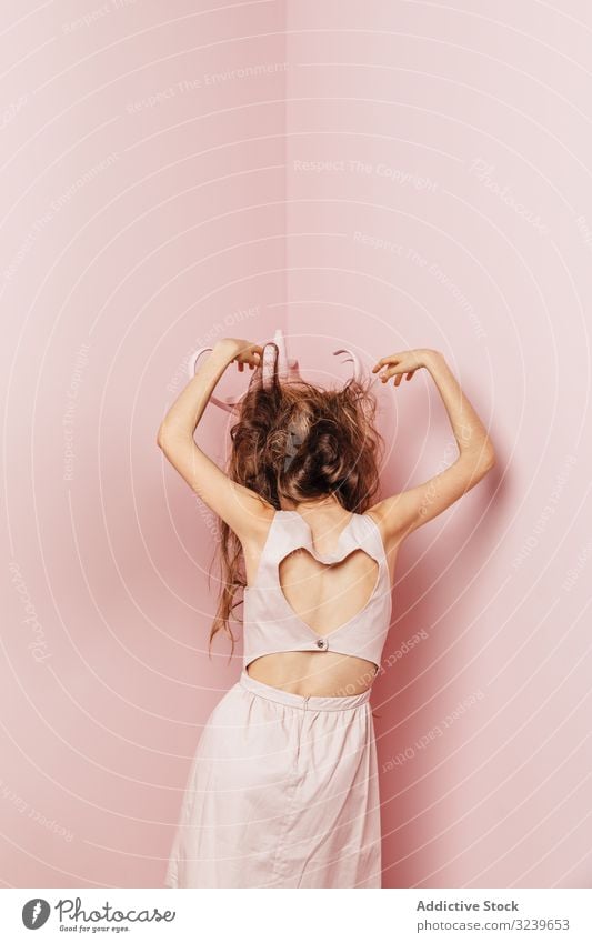 Rückenansicht eines jungen Mädchens Telefon Wand Lampe im Innenbereich rosa unzufrieden lange Haare wütend passiv Stehen unglücklich Frisur Verlust Stress