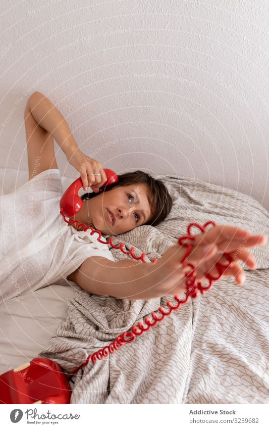 Frau im Telefongespräch Gespräch nachdenklich Bett zuhören Dialog Anruf Schlafzimmer Wand heimwärts Appartement flach retro altehrwürdig Mitteilung sprechen