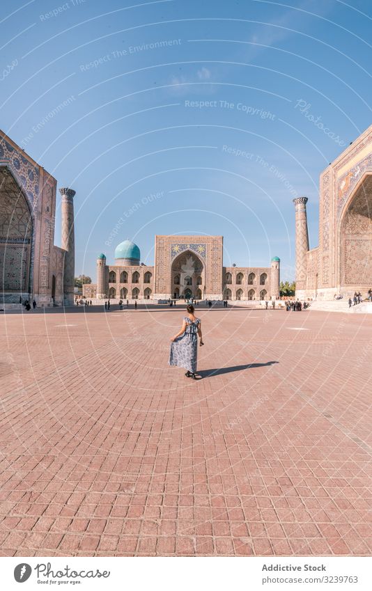 Nicht erkennbare Reisende auf dem Platz Tourist Gebäude traditionell Quadrat Spaziergang islamisch Ornament Frau Registan Samarkand Usbekistan gepflastert