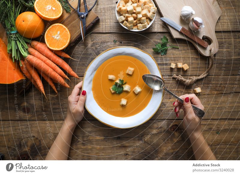 Personenhände halten Schüssel mit Karottensuppe Sahne Lebensmittel Schalen & Schüsseln Diät Gesundheit Gemüse Möhre Suppe orange abgestimmt Küche Teller frisch