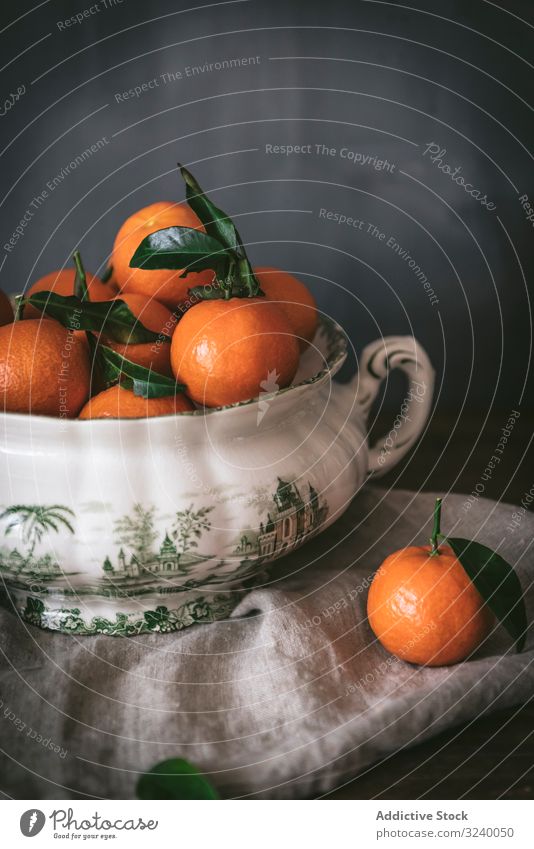 Orangefarbene Mandarinen in Keramik-Ornamentschale auf Holztisch anspruchsvoll Frucht Gesundheit klassisch Schalen & Schüsseln Zusammensetzung Stillleben Kunst