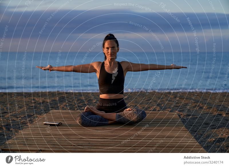 Erwachsene Frau meditiert abends am Meer Yoga MEER Strand Asana Aktivität Abend passen gekreuzte Beine Himmel wolkig positiv Sportbekleidung Training Fitness