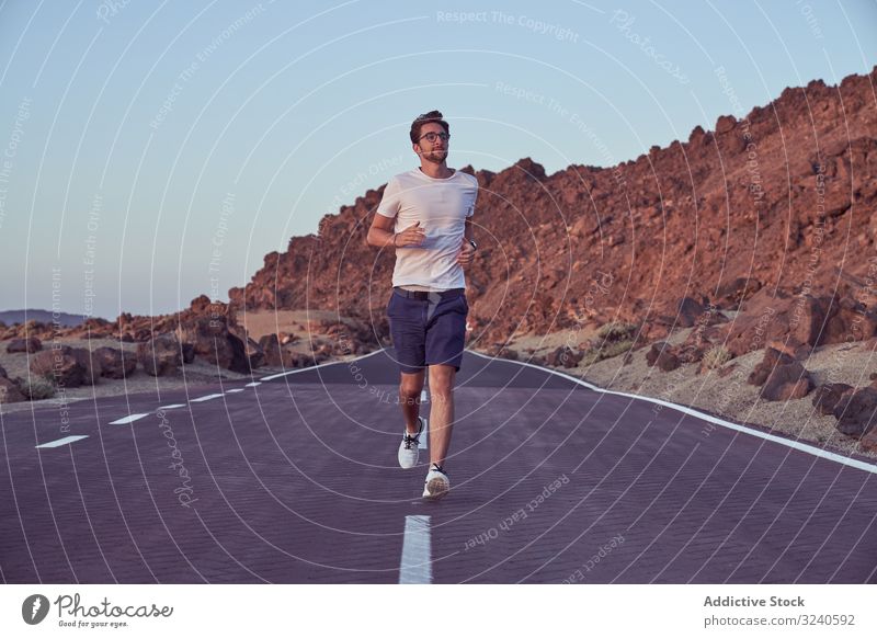 Aufgeregter Mann rennt auf Straße gegen Berglandschaft Berge u. Gebirge Landschaft laufen Reise Vulkan Asphalt umgeben felsig el teide Teneriffa Spanien