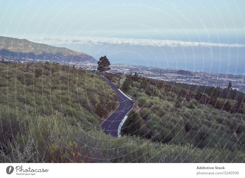 Blick auf die Straße, die unter Bergen zur Stadt hinunterführt Berge u. Gebirge Fahrbahn Park Insel Vulkan Teneriffa el teide Spanien Landschaft Asphalt