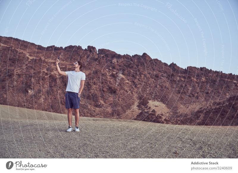 Mann benutzt Mobiltelefon in Teide, Spanien Berge u. Gebirge Vulkan felsig Insel Tourismus Teneriffa el teide reisen Gelände erkunden männlich Örtlichkeit