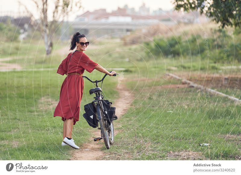 Frau mit Fahrrad im Park unterwegs Spaziergang Weg Lächeln lässig Großstadt Sommer Aktivität Fahrzeug Verkehr schieben Lifestyle ruhen sich[Akk] entspannen
