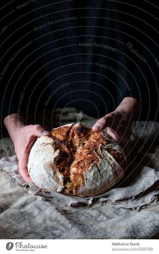 Erntehelfer, der das Brot auf den Stoff legt Person frisch zahlt Tisch Mahlzeit Lebensmittel Küche heimwärts Snack rustikal gebacken lecker Gewebe Gesundheit