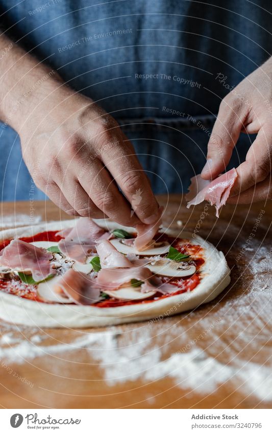 Erntehelfer legt Fleisch auf Pizza Mann Schinken Teigwaren Mehl weich frisch Küche Vorbereitung Lebensmittel Käse Tomate Pilz Kraut Saucen Küchenchef