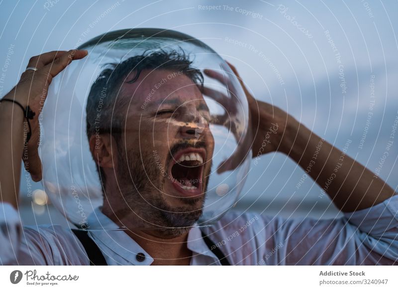 Verzweifelter Mann mit Aquarium auf dem Kopf schreit ernst Agonie furchtbar Meeresufer Fischbecken leer nass Verzweiflung führen Hemd stehen MEER Abend