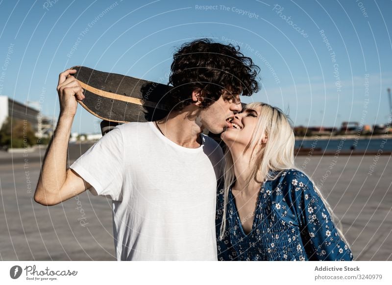Trendy verliebtes Paar umarmt sich auf der Straße Umarmung Skateboard Liebe Umarmen amour Windstille Romantik Freund Freundin charmant romantisch spielend