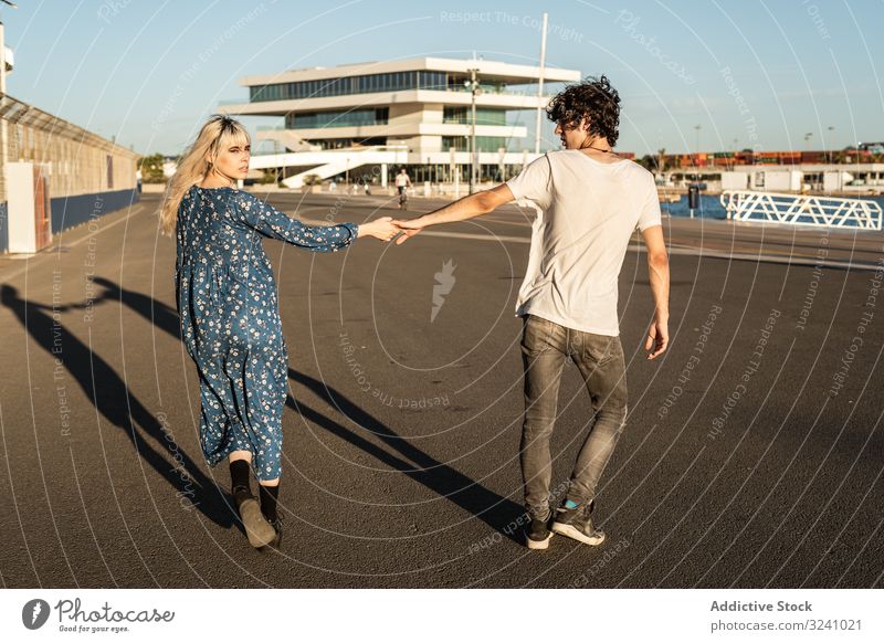 Paar hält sich beim Spaziergang entlang der Straße im Hafen an den Händen Weg Partnerschaft wählen Wahl Konzept Liebe Freund Freundin Neugier trendy Interesse