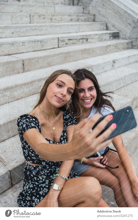 Lachende Frauen, die sich auf der Treppe eines alten Gebäudes egoistisch verhalten Selfie reisen Architektur Smartphone benutzend Dom Budapest Form