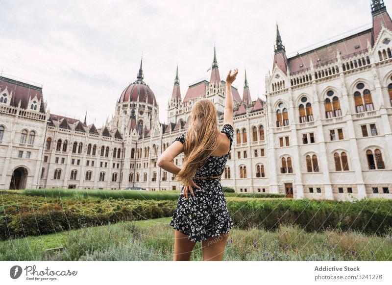 Langhaarige Frau hebt Hand zu altem alten Gebäude Architektur Palast Turm Tourismus erkunden Budapest Ungarn Form Kunst Dom reisen urban Großstadt geometrisch