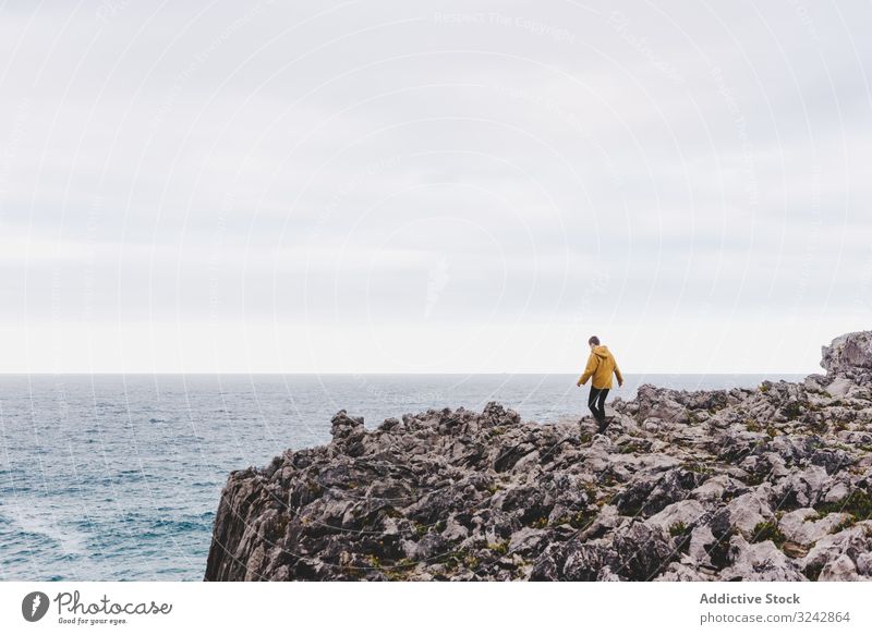 Reisender in der Einsamkeit beim Wandern an felsiger Küste Seeküste erkunden Spaziergang Stein Fernweh Ufer Kontemplation einsam Sweatshirt MEER Meer Kapuze