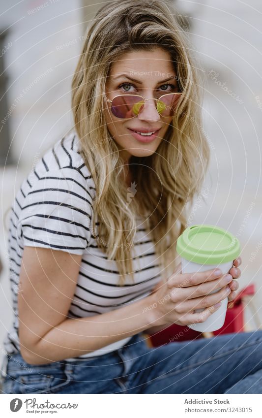 Glückliche Frau mit Einwegkaffee auf Straßenbank sitzend Bank Großstadt Kaffee Strandpromenade freudig genießen lässig ruhen jung Lachen Lächeln aufgeregt schön