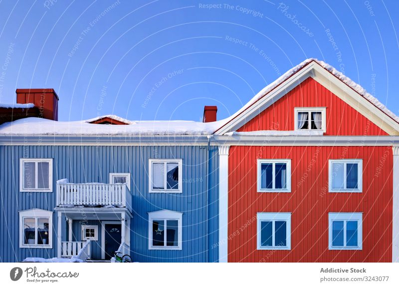 Blau-rote Hütte in Winterlandschaft Dorf Schnee Haus Baum laublos sonnig tagsüber Himmel wolkenlos Windstille Sauberkeit weiß blau Landschaft Wohnsiedlung kalt