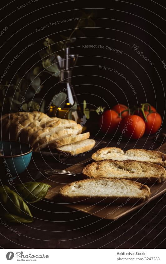 Toastet Zutaten auf dunklem Tisch Zuprosten Bestandteil Brot Basilikum Tomate Lebensmittel dunkel Mahlzeit frisch rustikal traditionell Abendessen Mittagessen
