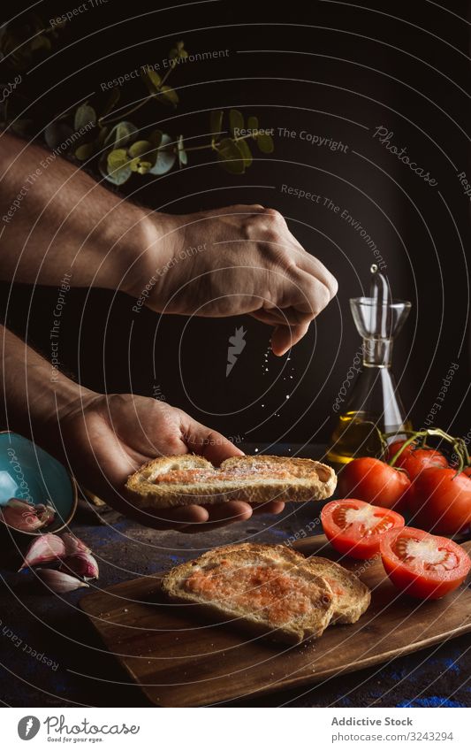Erntehelfer gießt Salz auf Toasts Person Zuprosten Koch eingießen Erdöl Brot Saucen Tomate Lebensmittel Speise lecker geschmackvoll frisch Spielfigur Scheibe