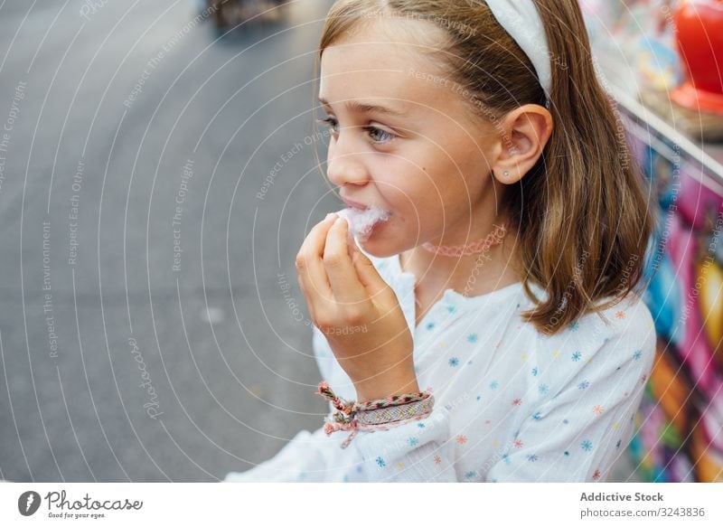 Fröhliches Mädchen isst Zuckerwatte auf der Straße Verkaufswagen essen Lächeln Großstadt Fairness Freude Kind Glück urban Stadt süß Spaß Anbieter kaufen