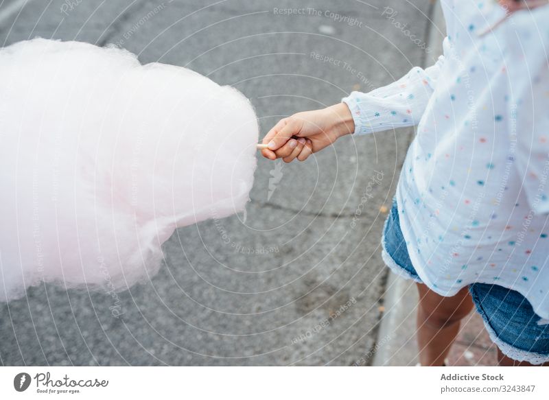 Fröhliches Mädchen isst Zuckerwatte auf der Straße Verkaufswagen essen Lächeln Großstadt Fairness Freude Kind Glück urban Stadt süß Spaß Anbieter kaufen