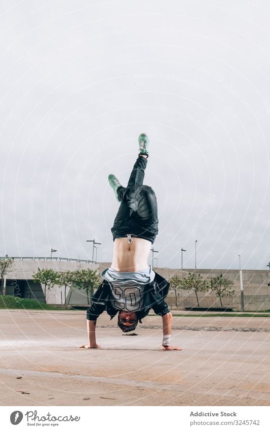 Geschickter Breakdancer mit Handstand in der Bewegung cool stylisch Kultur Streetstyle Lifestyle Hip-Hop flippig Stil Freestyle Spaß Leistung Sport Straße jung
