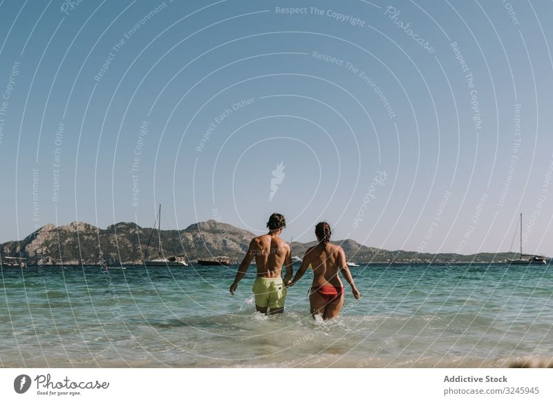 Glückliches Paar beim Spaziergang auf dem Meer Mann Frau Umarmung MEER Freundschaft Partnerschaft Badeanzug Bonden hübsch brünett alternativ Badebekleidung