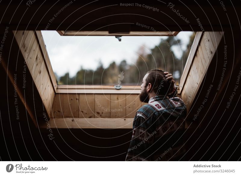Mann im Urlaub, der zu Hause vom Dachfenster aus genießt Betrachtung Deckenbeleuchtung Fenster Natur Design Zimmerdecke Innenbereich heimwärts Appartement