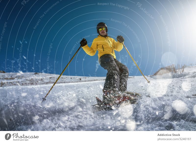 Mann beim Skifahren am Wintertag Mitfahrgelegenheit Berghang Schnee Resort extrem Oberbekleidung Sonnenbrille kalt Sport Urlaub Lifestyle Erholung Frost