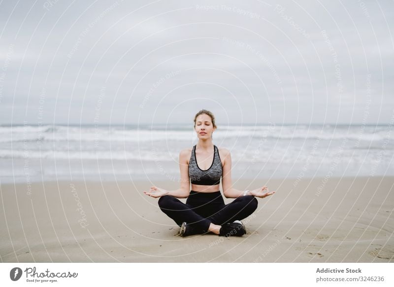 Am Strand meditierende Frau Yoga üben MEER Meer Übung Training jung Athlet aktiv Windstille Ruhe Sportbekleidung Körper Fitness Gesundheit Wellness passen