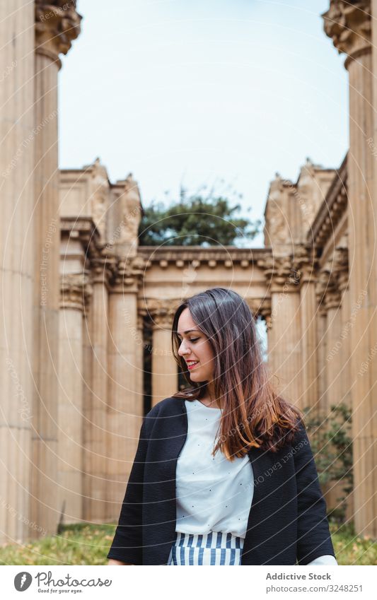 Aktive Frau geht zwischen alten Gebäudesäulen im Freien laufen Spalte antik geometrisch Architektur Park abstützen Erwachsener Design reisen Straße