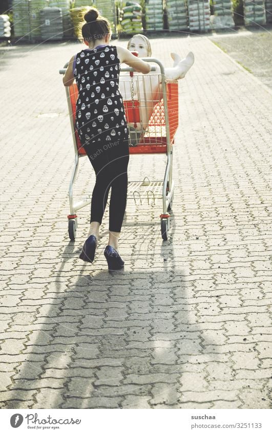 shoppen gehen Mädchen Kind Junge Frau Jugendliche Teenager Einkaufswagen kaufen Schaufensterpuppe skurril lustig seltsam Spaziergang Freude schieben