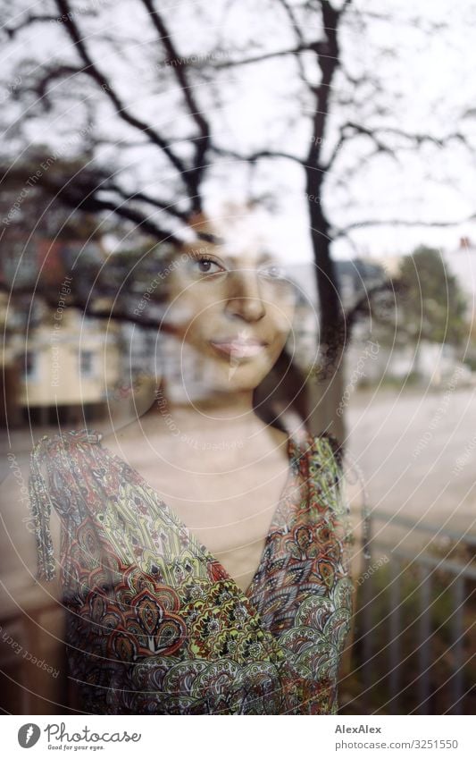 Portrait einer Frau hinter einer Fensterscheibe Stil schön harmonisch Wohnung Stadt Junge Frau Jugendliche 18-30 Jahre Erwachsene Schönes Wetter Baum Straße